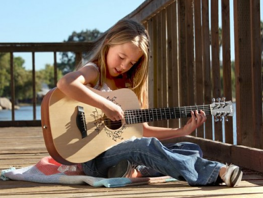 bé học đàn guitar